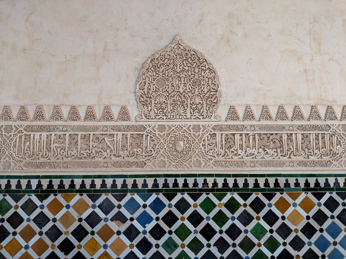 Detailed Islamic wall carvings and geometric patterns inside the Alhambra