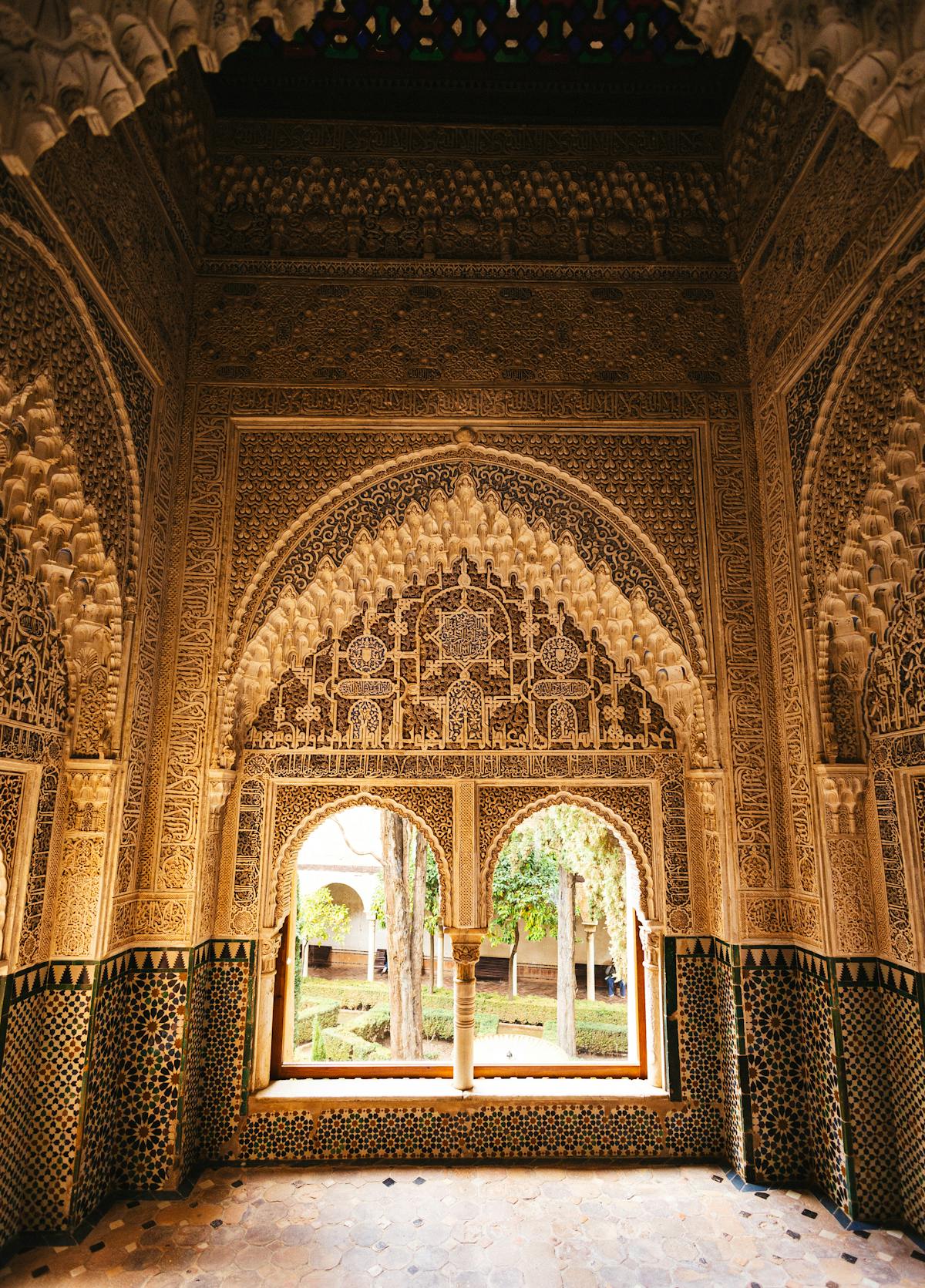 Carved Moorish archways inside the Alhambra Palace in Granada showing intricate Islamic art