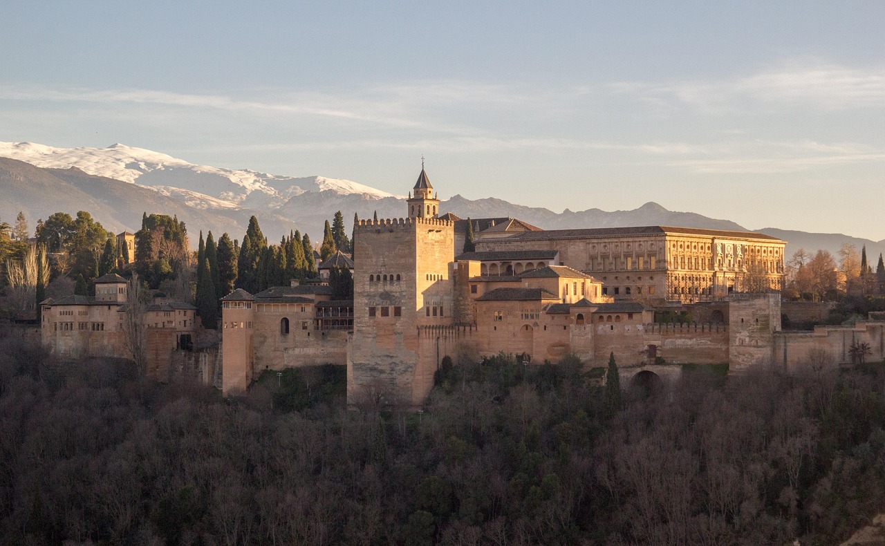 The Alhambra at sunset with the Sierra Nevada mountains behind it, seen from the Albaicin