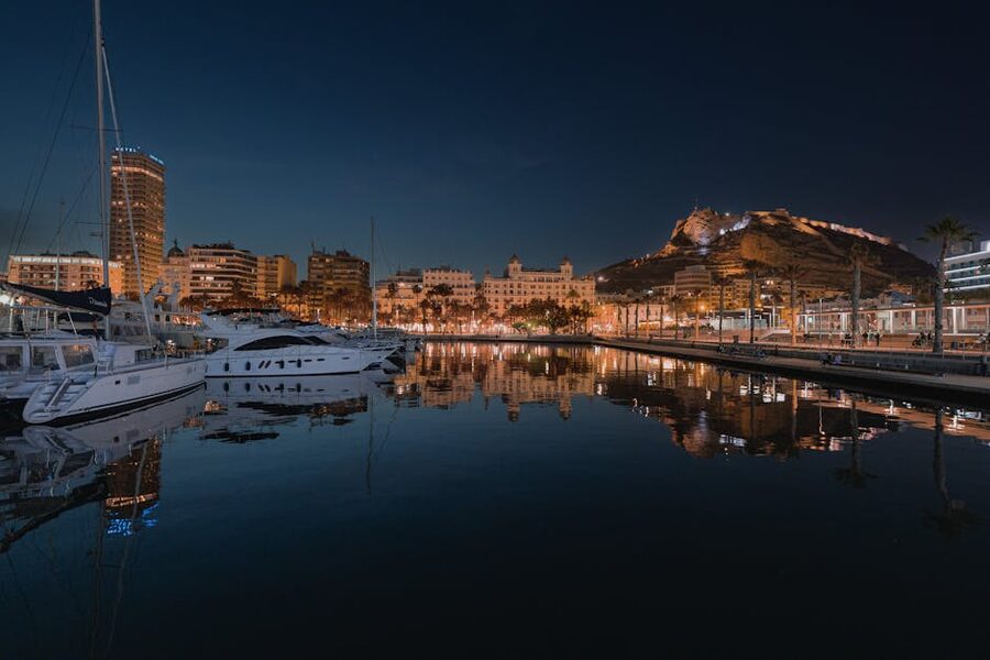 Alicante harbor illuminated at night with Santa Barbara Castle above