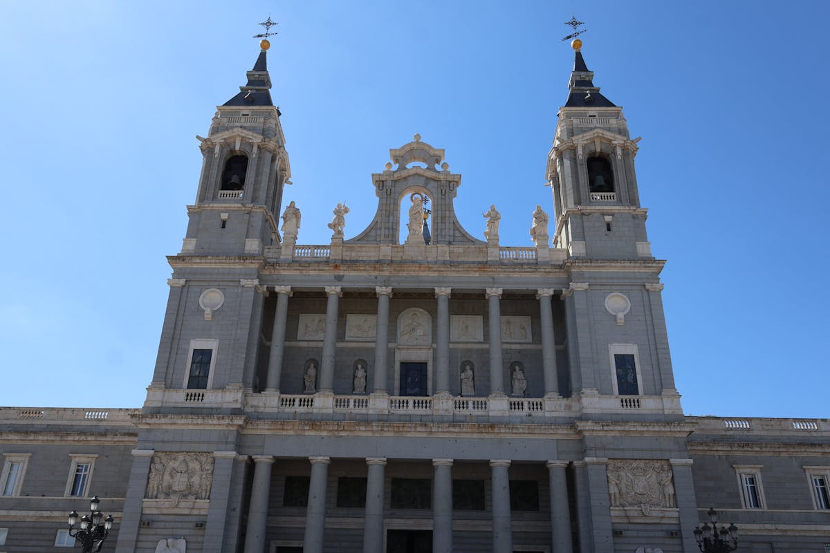 Front view of Almudena Cathedral in Madrid under clear blue sky