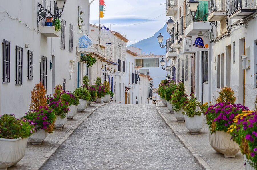 Narrow alley in Altea Spain with flowers and whitewashed walls