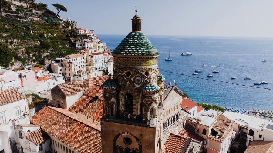 View of Amalfi town nestled in a ravine between steep green hillsides