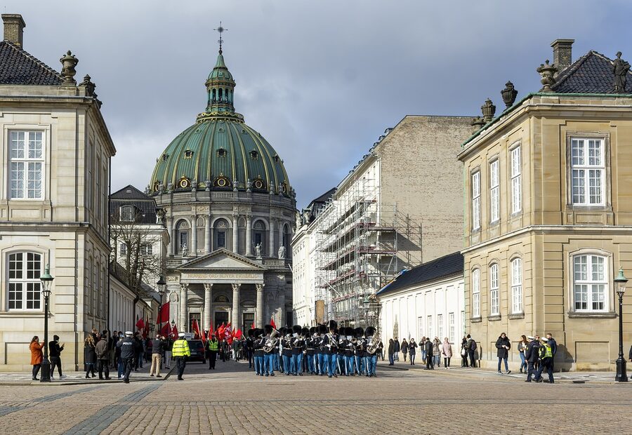 Royal Guards in blue uniforms marching during changing of the guard at Amalienborg Palace Copenhagen
