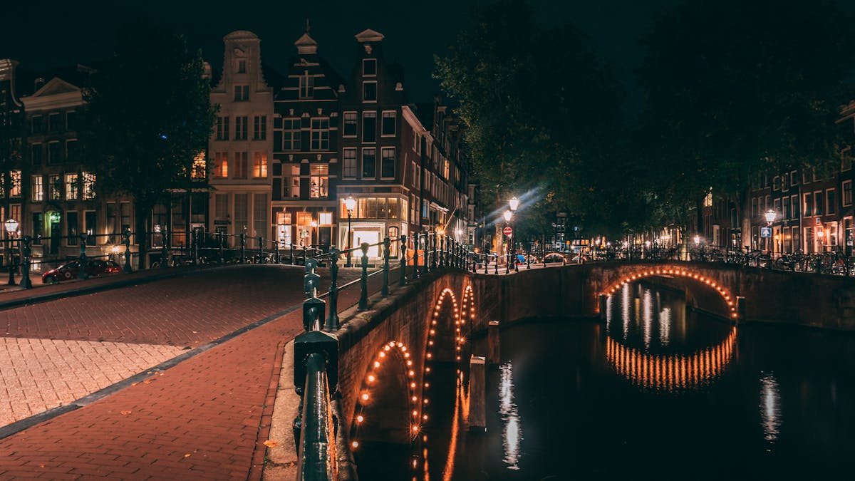 Amsterdam canal with illuminated bridges at night