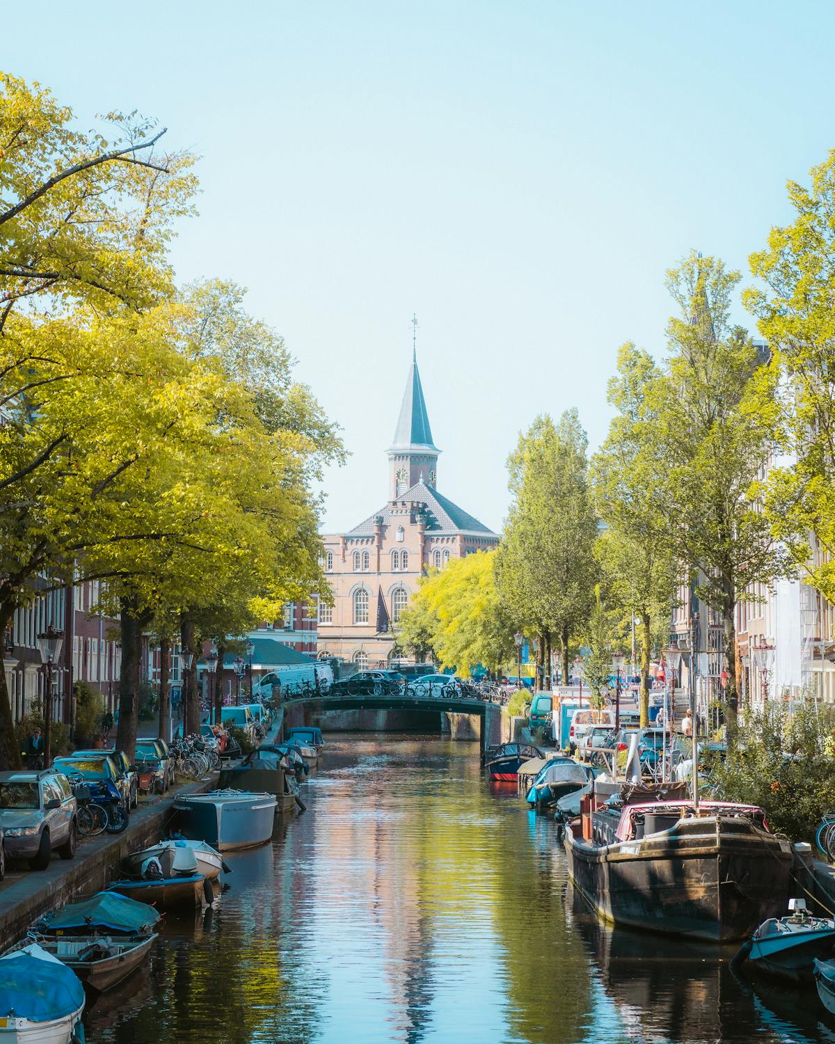 Scenic Amsterdam canal with boats, bridge, and church