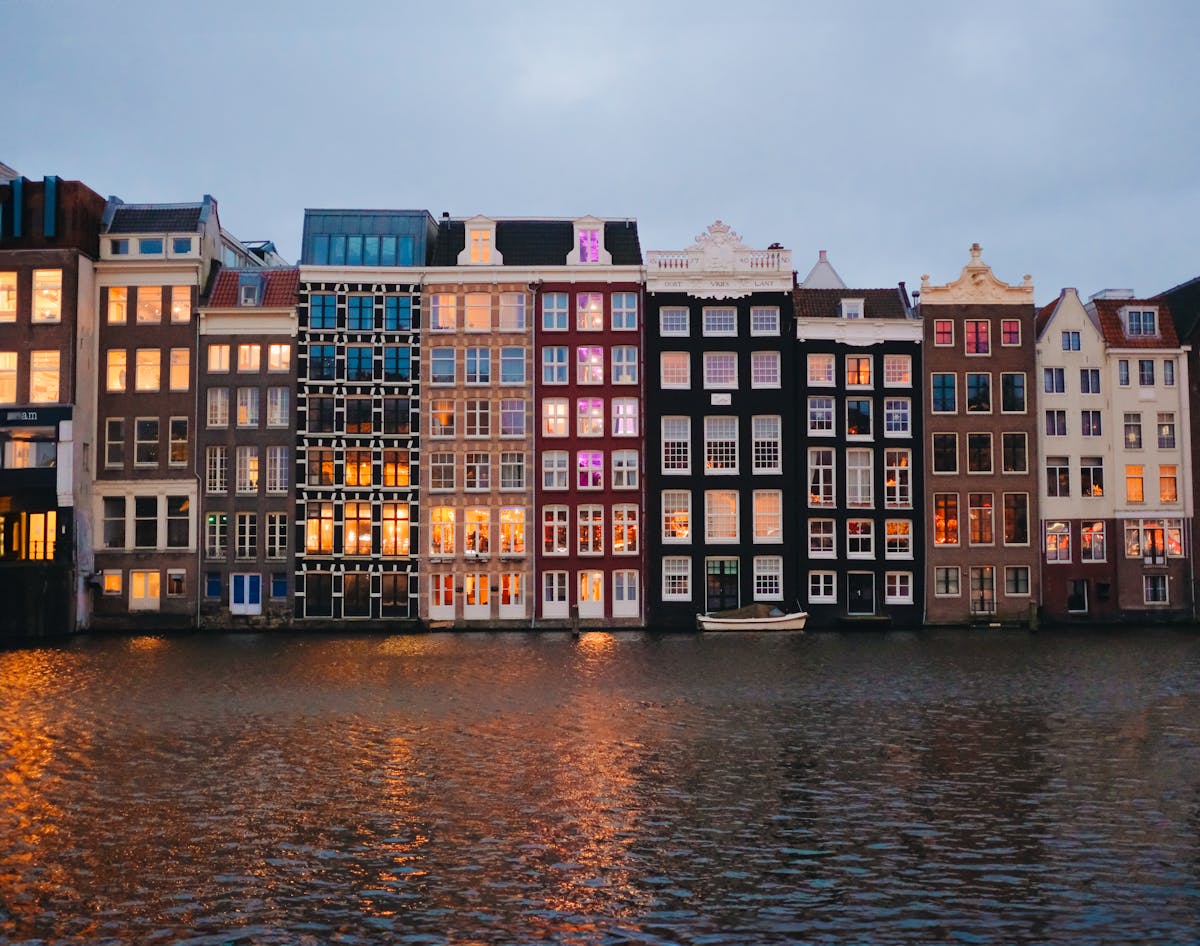 Amsterdam canal houses reflecting on water at dusk