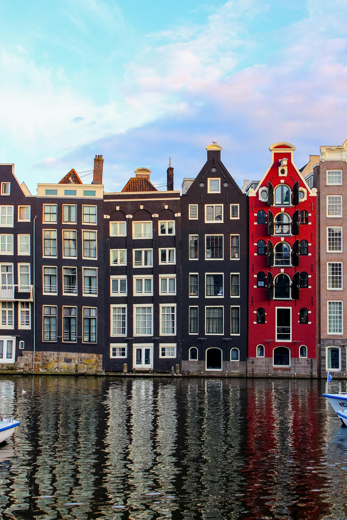 Amsterdam canal houses reflecting in water at sunrise