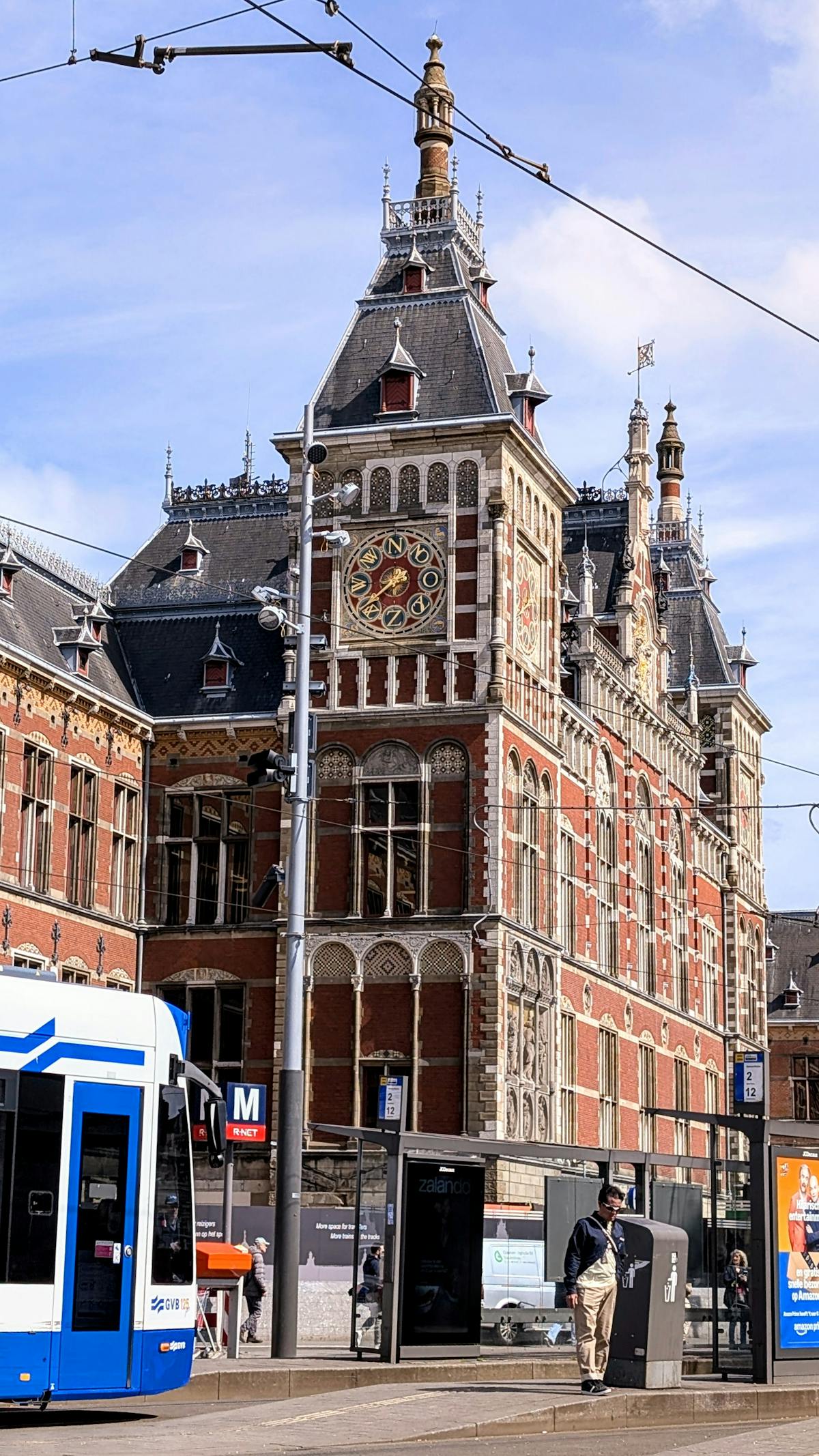Amsterdam Centraal Station exterior with clock tower and tram