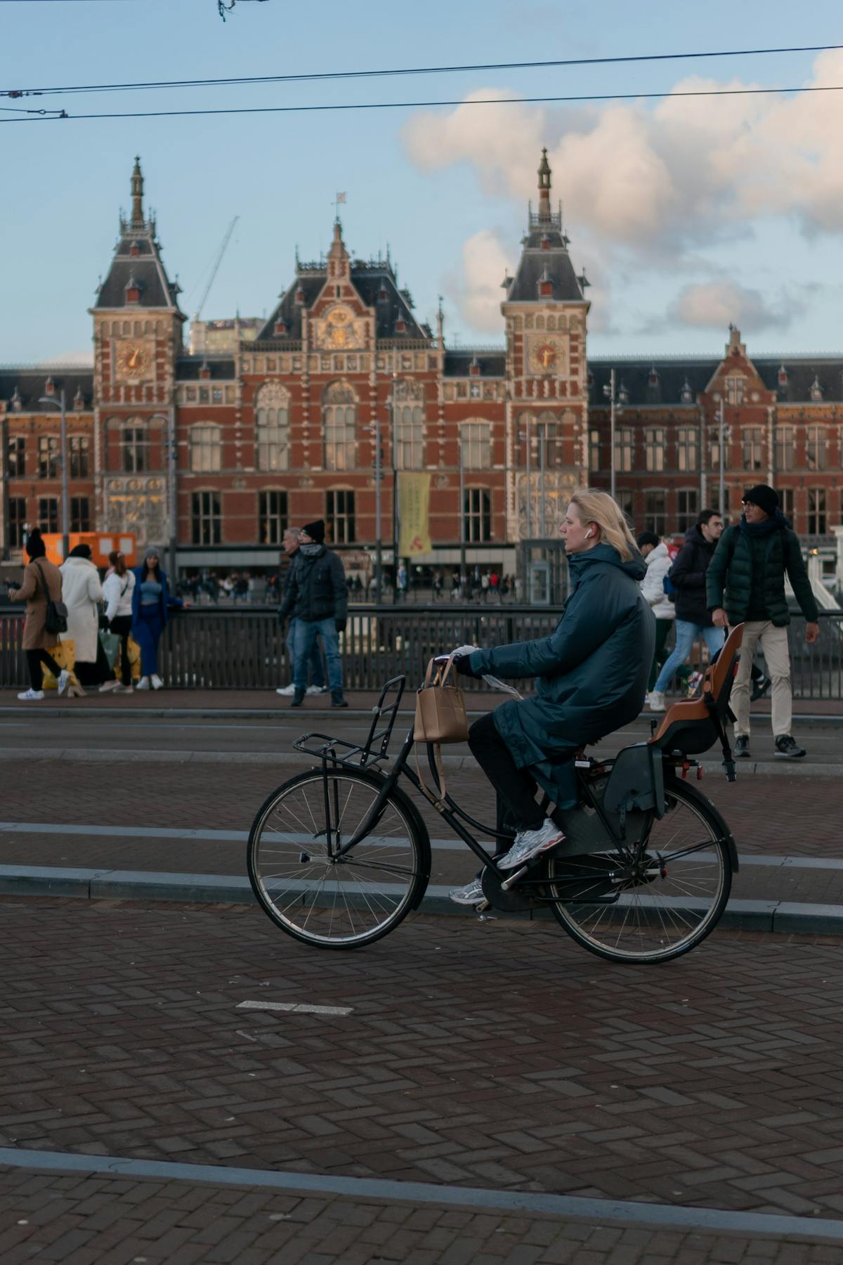 Cyclist rides by Amsterdam Central Station
