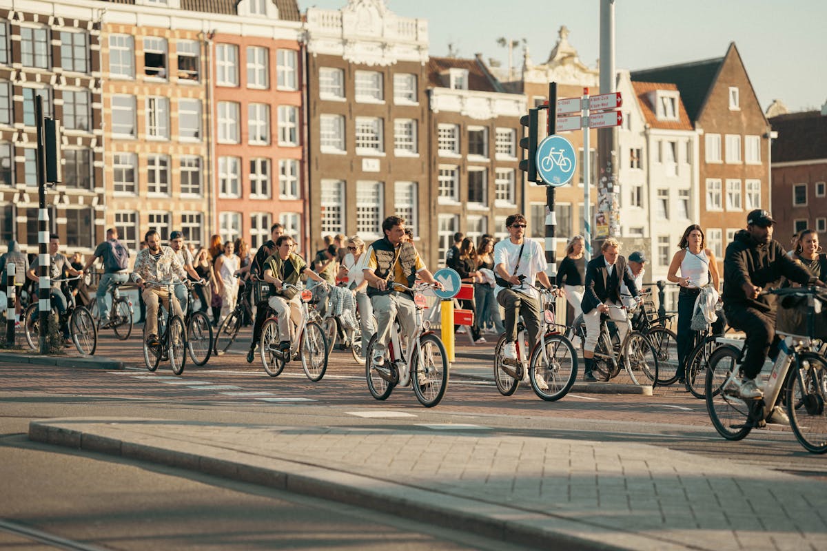 People cycling through a sunny Amsterdam street