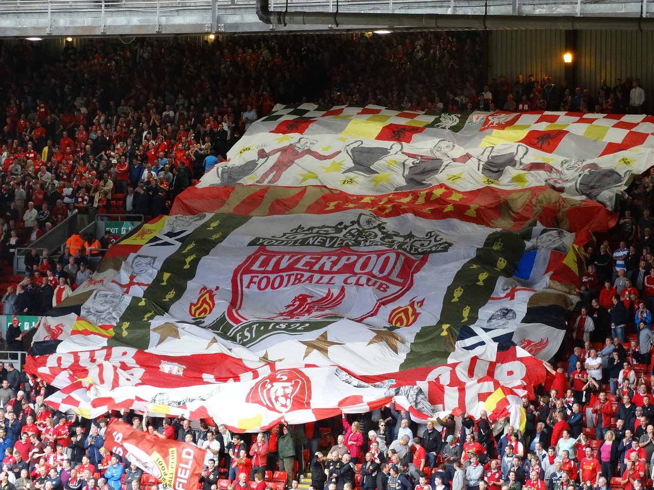 Liverpool FC fans in the Kop end with a giant red flag