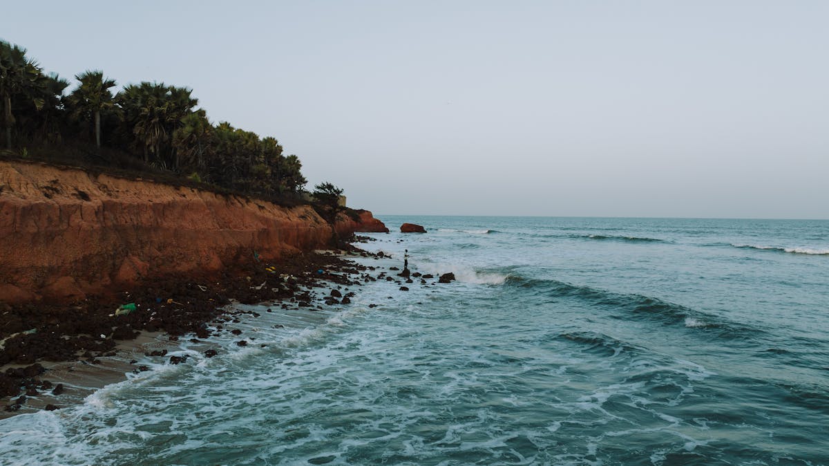 Red cliffs along the Antalya coastline with palm trees