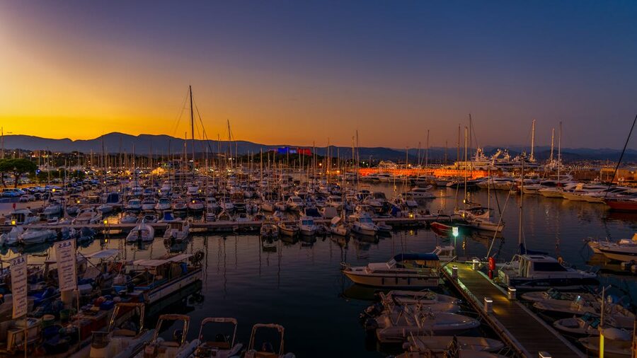 Sunset over Antibes marina harbour with boats and warm golden light