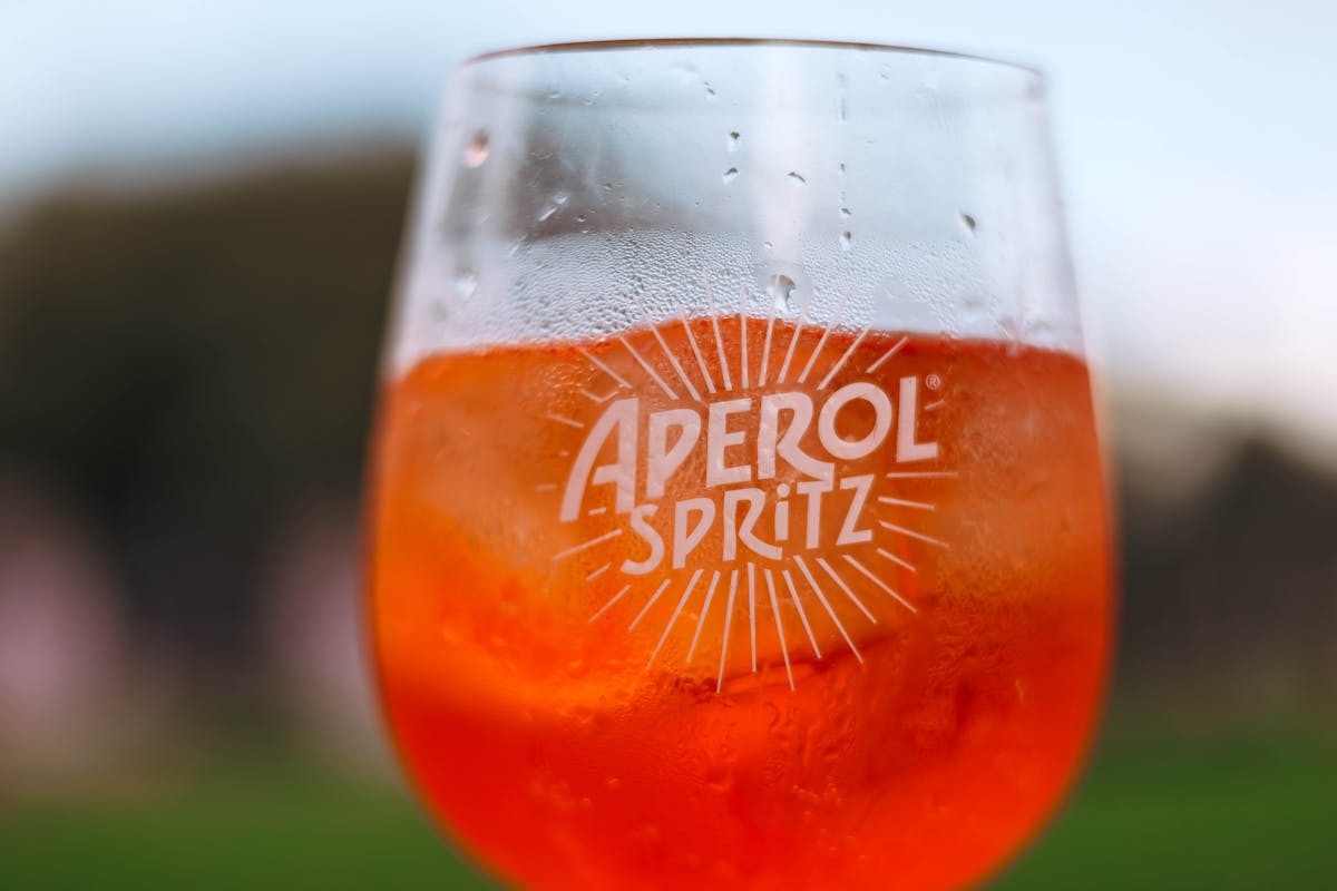Refreshing Aperol Spritz cocktail with orange slice in sunlight