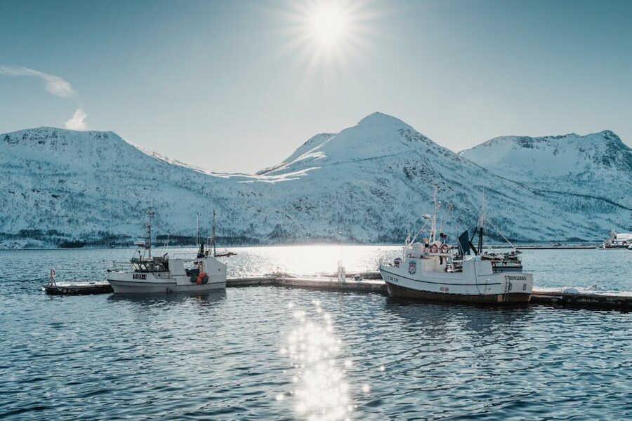 Arctic fishing boats in snowy harbor at sunrise