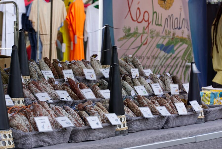 Colorful selection of cured artisan sausages hanging at a French market stall
