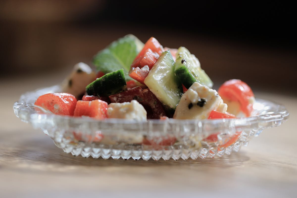 Greek salad with feta cheese, cucumbers and tomatoes in a glass dish