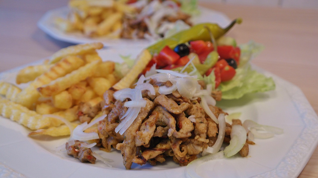 Full Greek gyros plate with tzatziki sauce, vegetables and salad