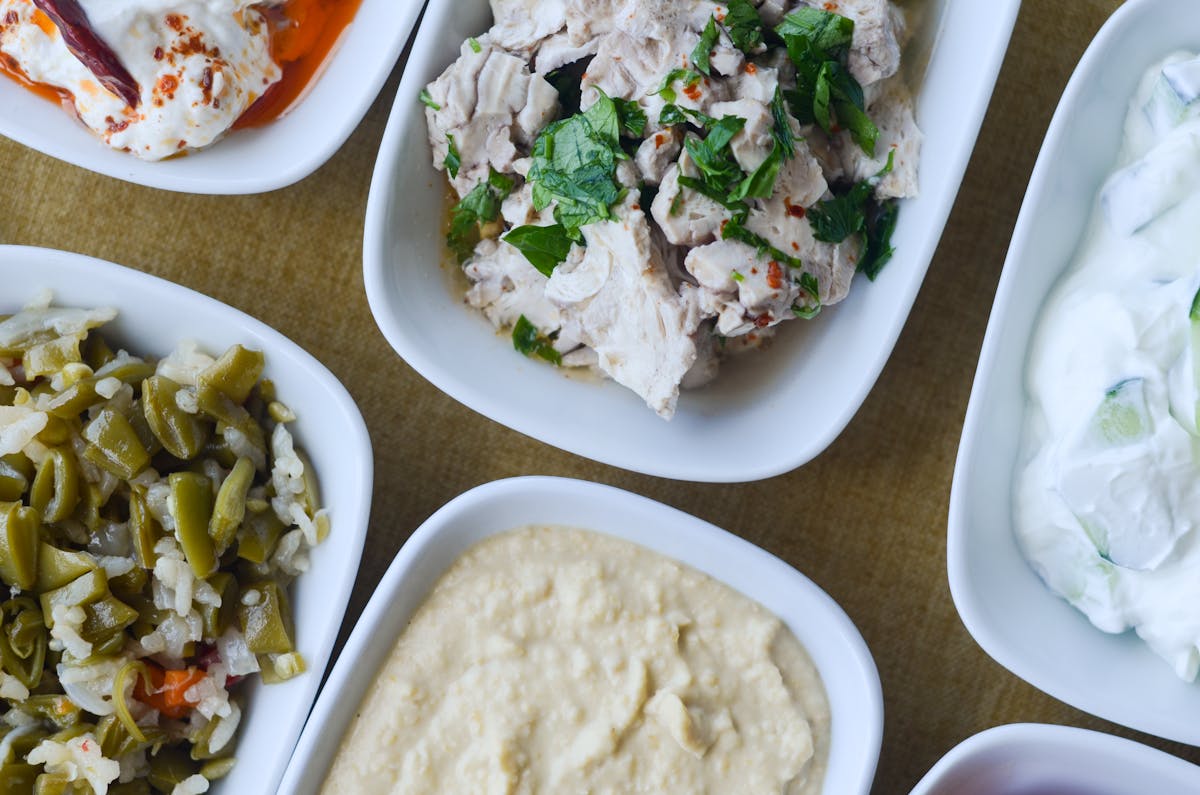 Assortment of Mediterranean dishes served in white bowls on a table