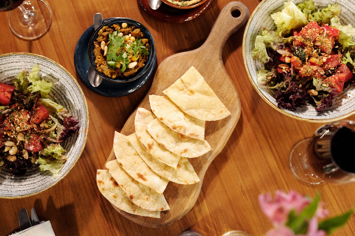 Mediterranean food spread with pita bread, salads and wine