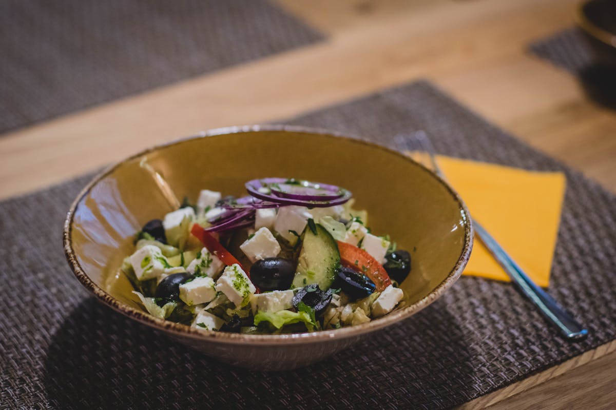 Greek salad with feta cheese, olives and vegetables in a ceramic bowl