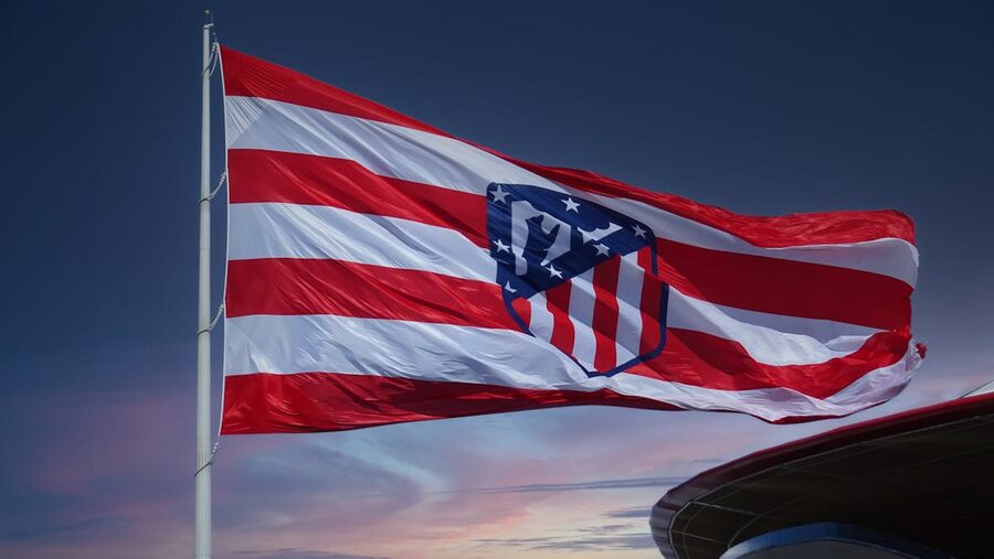Atletico Madrid flag flying against a sunset sky at a football match