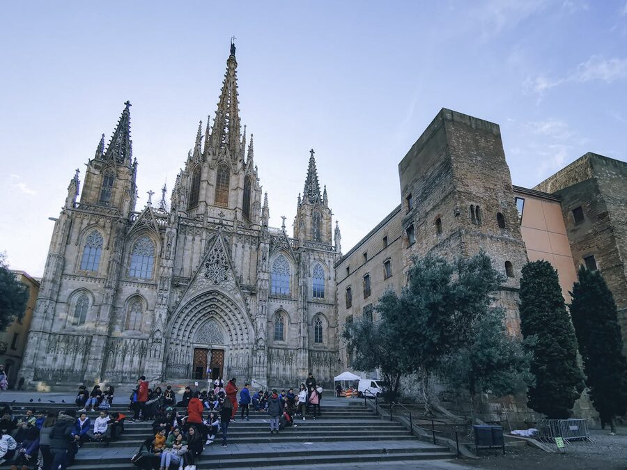 Gothic cathedral facade in Barcelona with people on steps