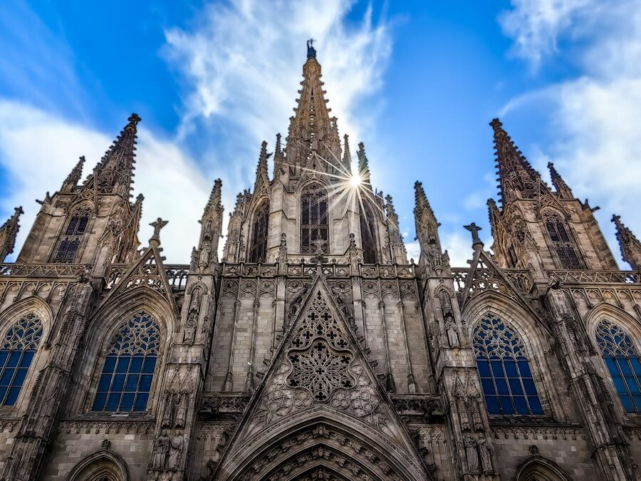 Sun bursting over Barcelona Cathedral spire creating dramatic light
