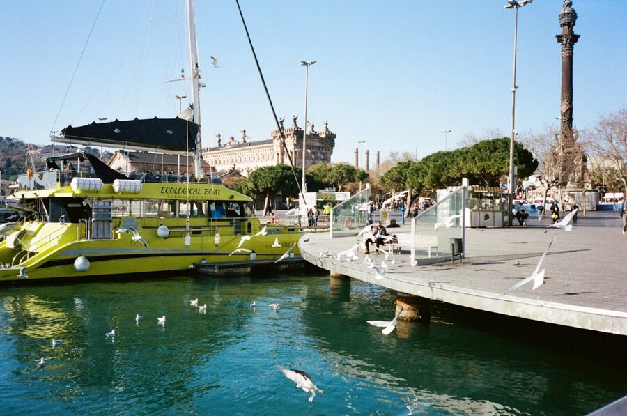 Ecological tour boat docked at Barcelona harbour with seagulls