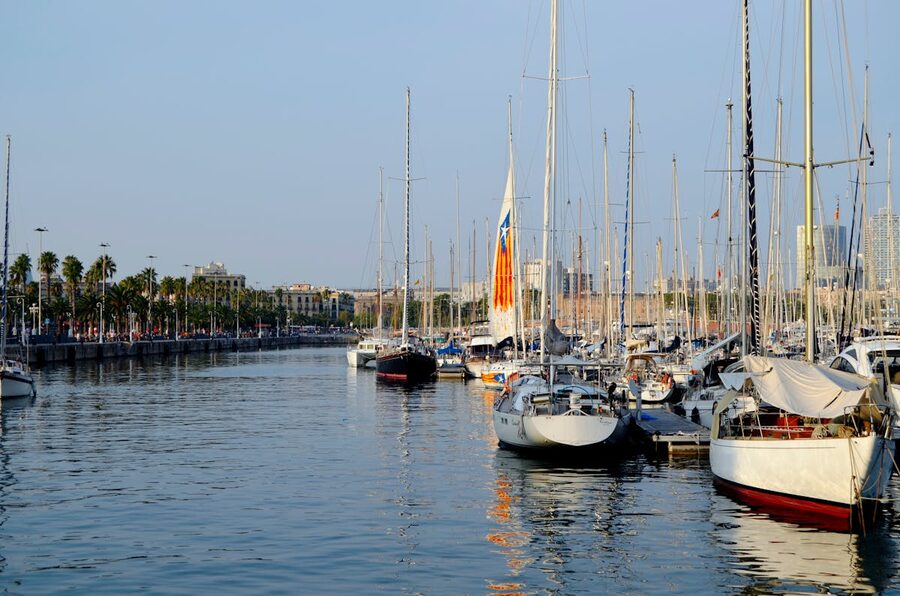 Sailboats moored at Port Vell marina with Barcelona skyline behind