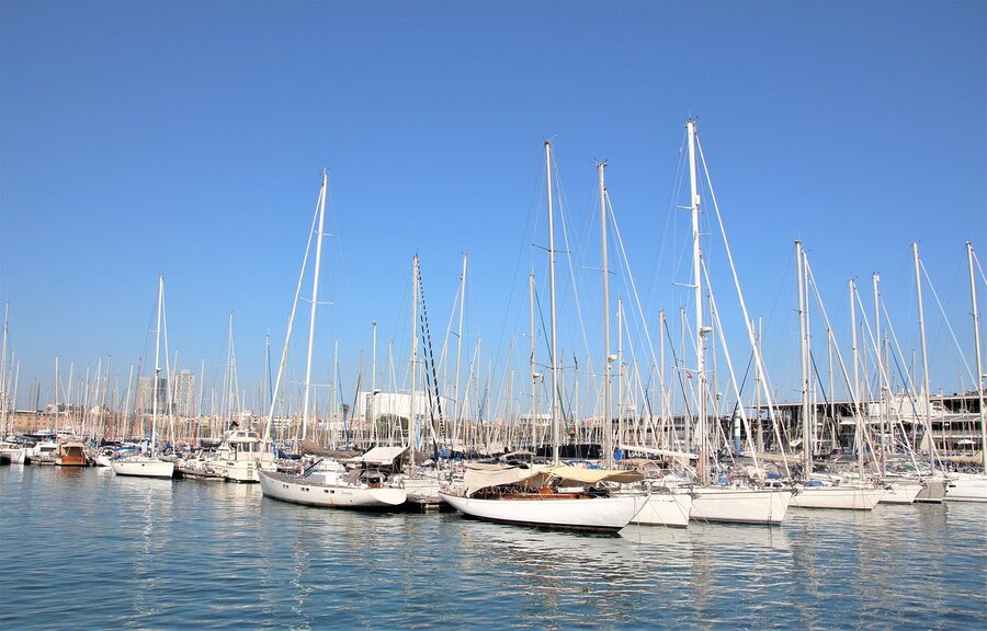Barcelona port with various boats moored under clear sky