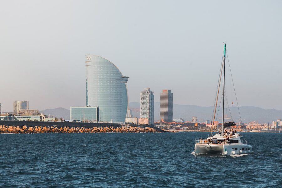 Sailing boat on Mediterranean with Barcelona coastline behind