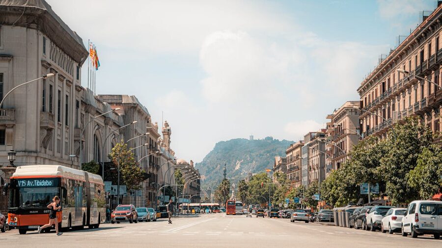 Barcelona urban street scene with Montjuic mountain in background