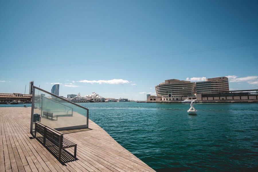 Wooden pier extending into Barcelona harbour with modern buildings