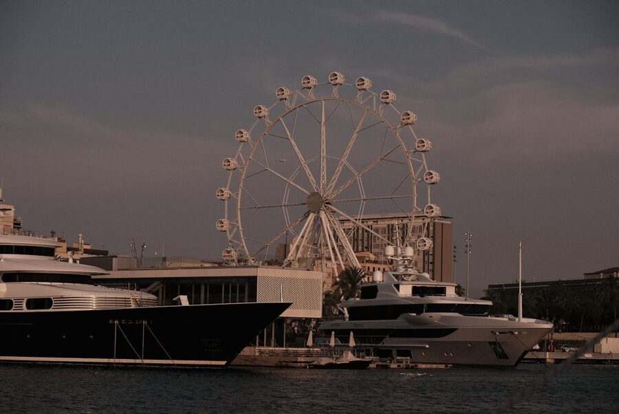 Barcelona harbour at sunset with yachts and ferris wheel