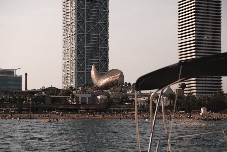 Sailboats off Barceloneta beach at sunset with Frank Gehry fish sculpture