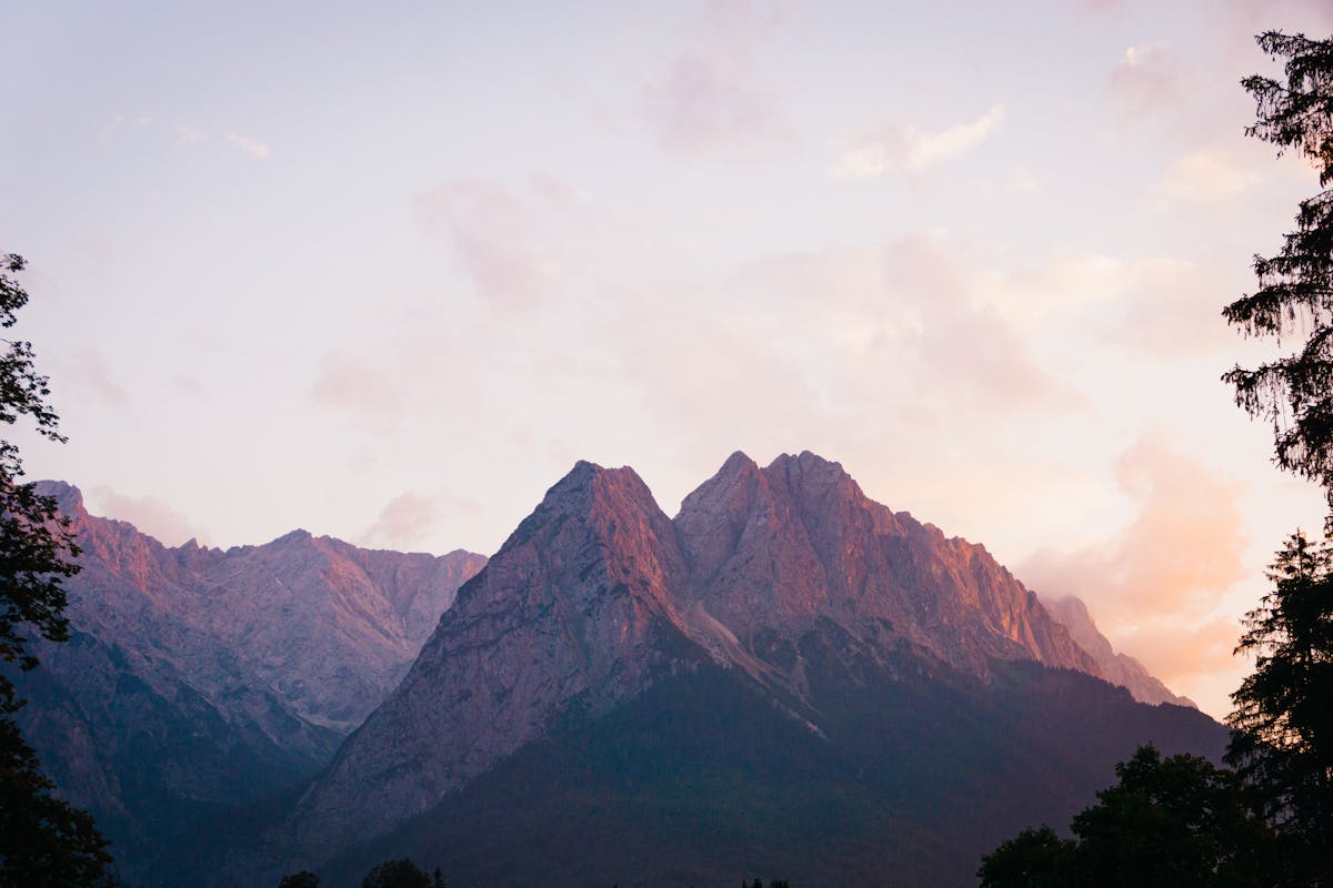 Soft sunset light bathing the Bavarian Alps in warm pink and gold tones