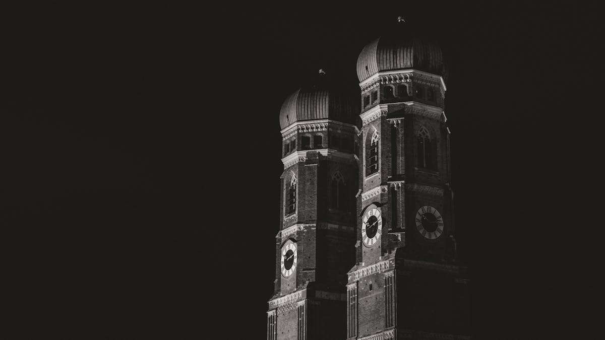 Black and white photograph of Frauenkirche towers illuminated at night in Munich
