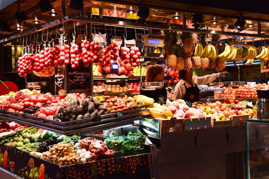 Colorful fruit stand in La Boqueria Market Barcelona with fresh produce under warm lights