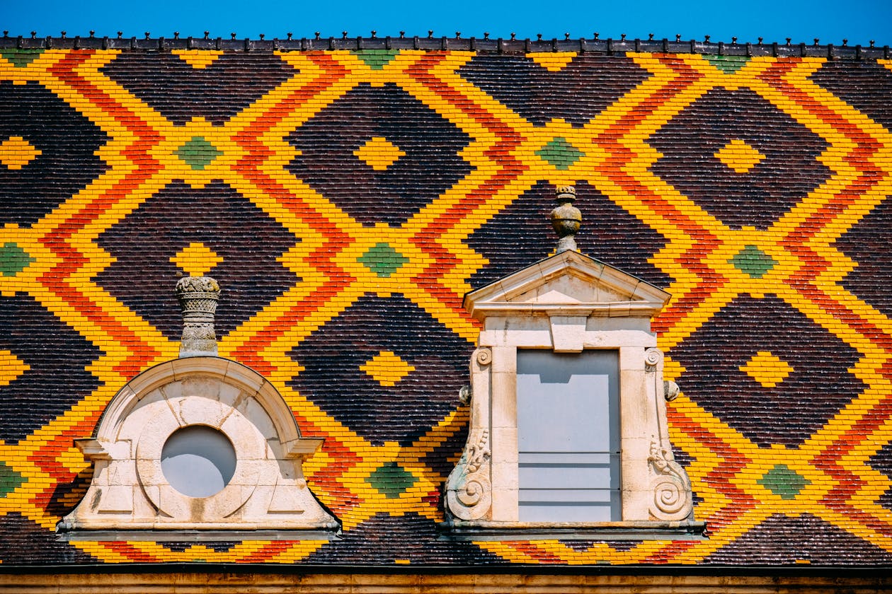 Close-up of the colourful geometric glazed tile roof pattern on a historic building in Beaune France