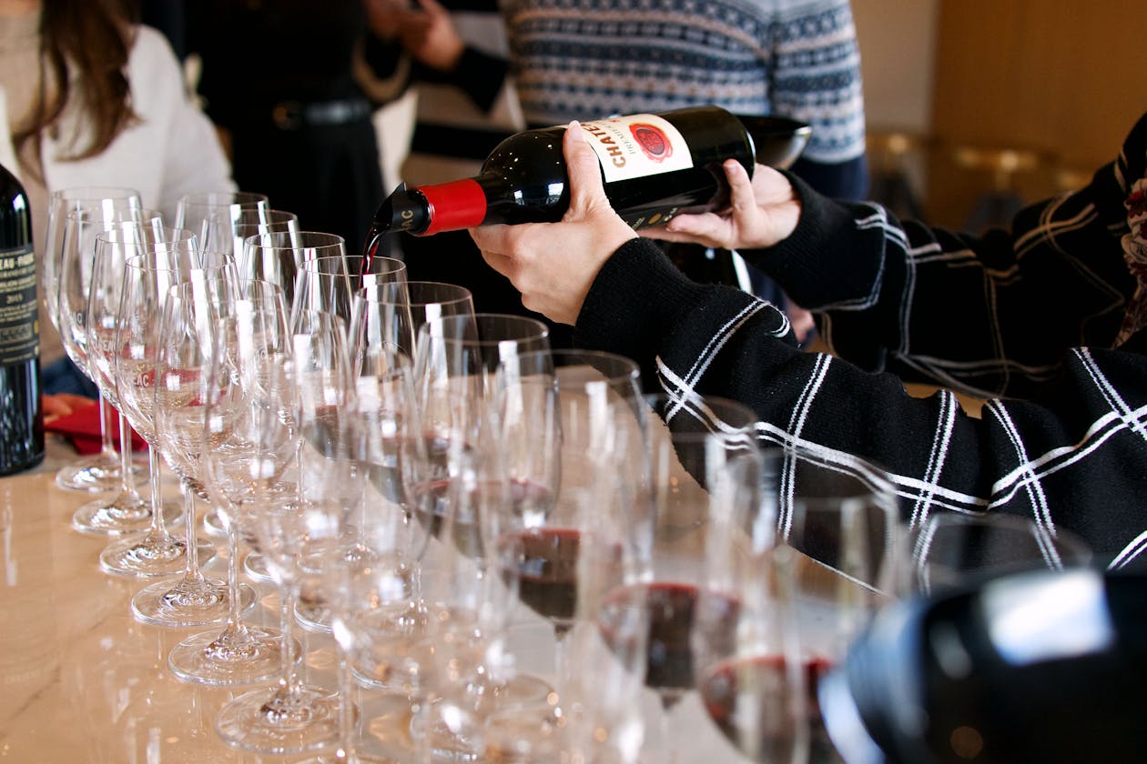 Wine tasting setup showing multiple glasses of wine on a wooden surface in a French winery