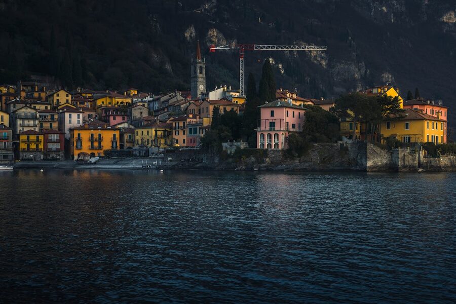 Colourful village buildings lit at dusk along Lake Como waterfront