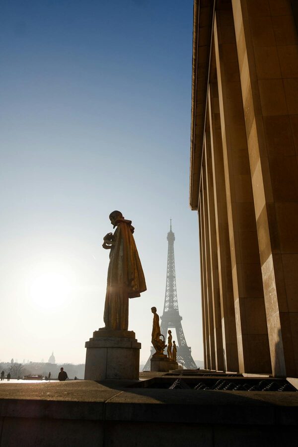 The Eiffel Tower bathed in golden sunrise light over the Paris skyline