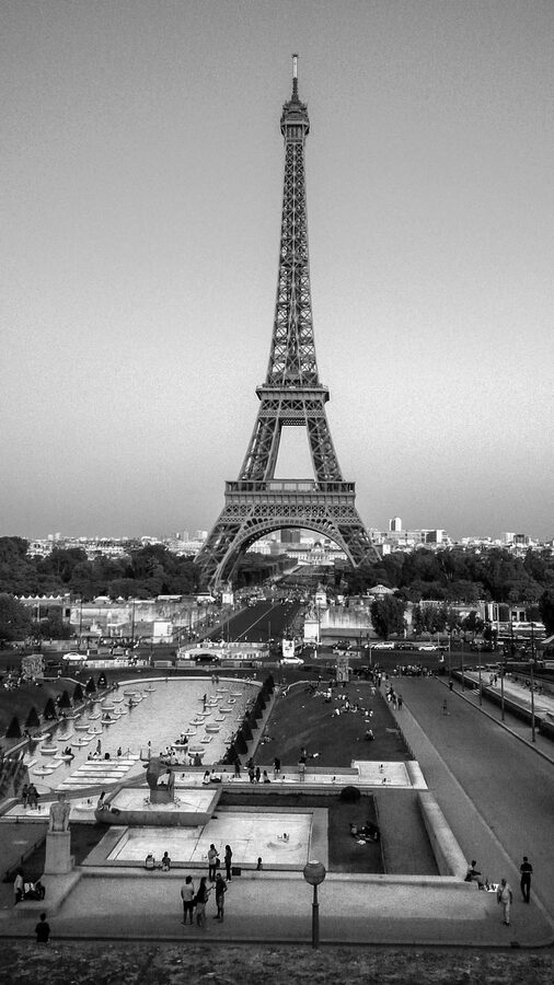 A Parisian cafe terrace with chairs and tables on a street near the Eiffel Tower