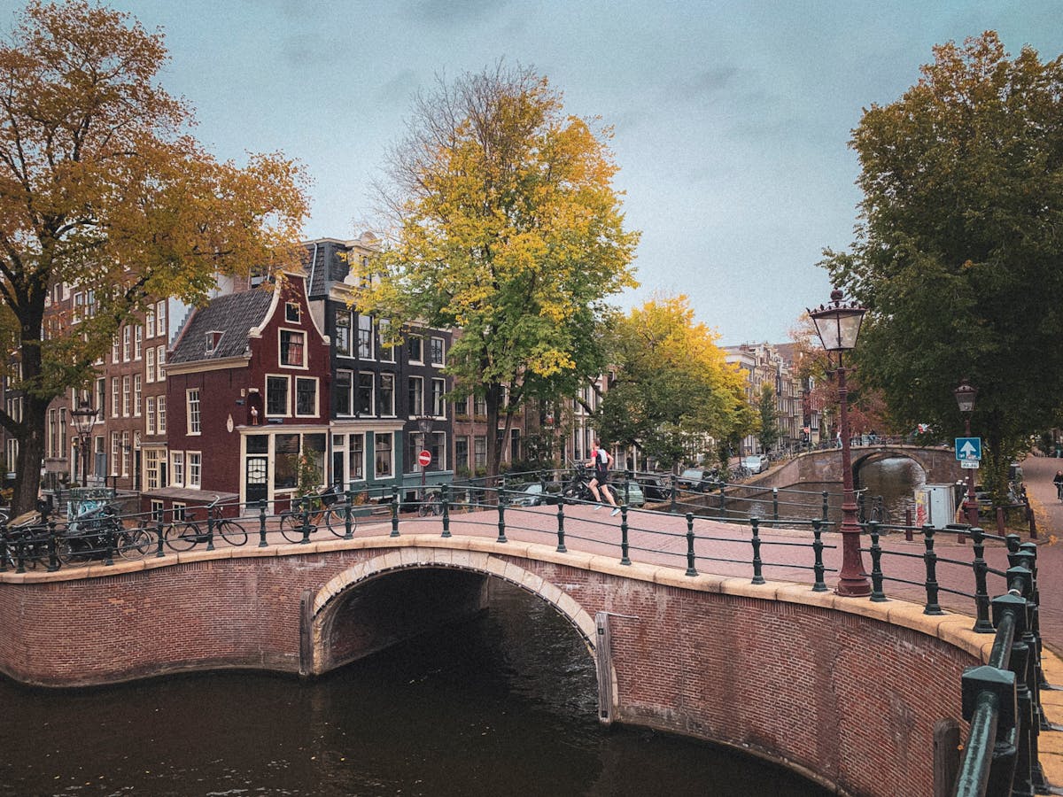 Amsterdam canals and pedestrian bridge with autumn foliage