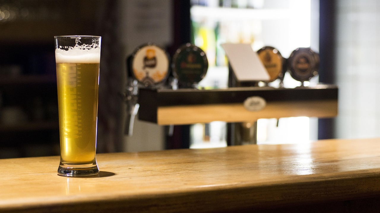 Two glasses of beer on a wooden pub table
