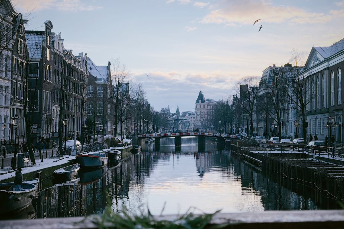Peaceful winter view of an Amsterdam canal with boats and classic architecture