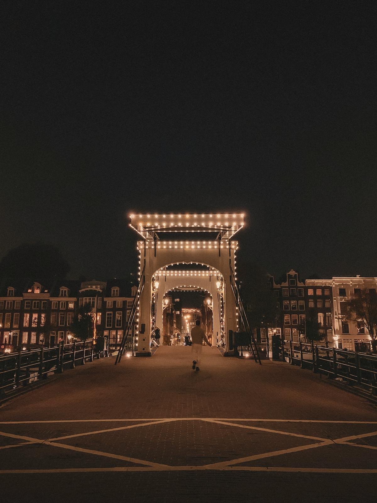 The Magere Brug in Amsterdam lit up at night with Dutch architecture