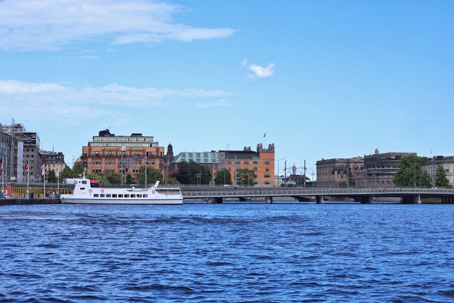 A peaceful scene of Stockholm waterfront featuring a passenger boat and city buildings